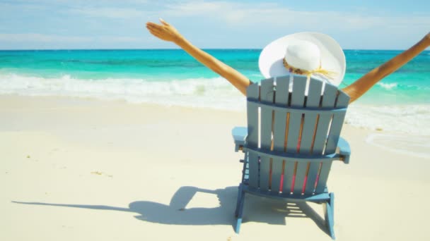 Chica tomando el sol en silla de madera en la playa tropical — Vídeo de stock