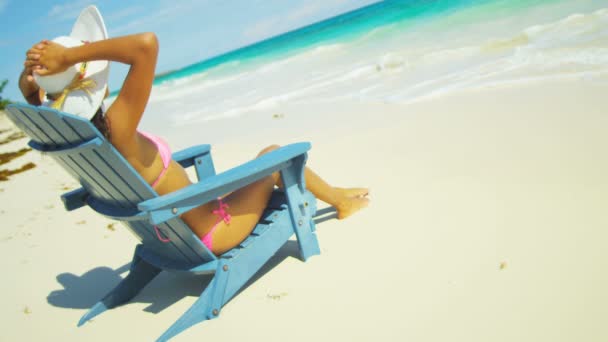 Girl sunbathing on wooden chair on tropical beach — Stock Video