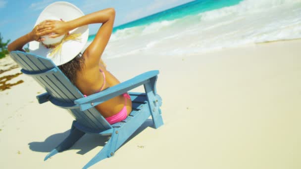 Chica tomando el sol en silla de madera en la playa tropical — Vídeos de Stock