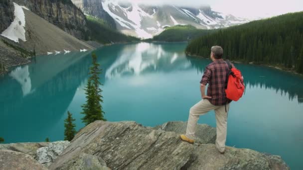 Senderismo Hombre Mirando el lago Moraine — Vídeo de stock
