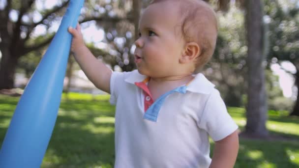 Niño jugando bate de béisbol de plástico — Vídeo de stock