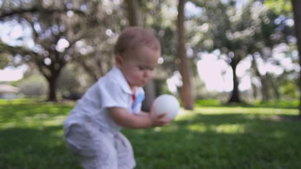 Boy walking barefoot on grass in park — Stock Video