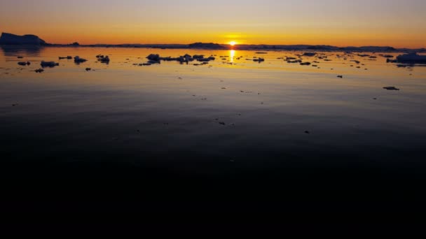 Gletsjer ice floes drijvend in het water bij zonsondergang — Stockvideo