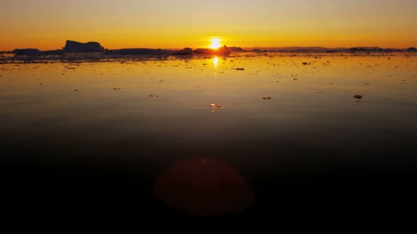 Floes glaciaires flottant dans l'eau au coucher du soleil — Video