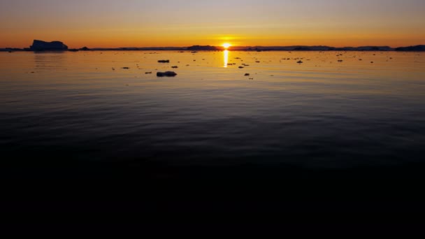 Glacier ice floes floating in water at sunset — Stock Video