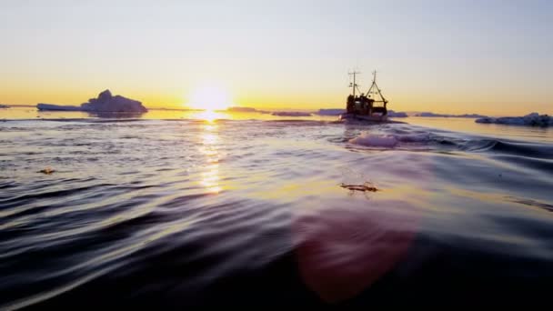 Barco de pesca flotando en el agua al atardecer — Vídeos de Stock