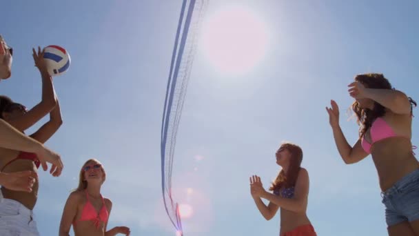 Друзі коледжу грають у волейбол на пляжі — стокове відео