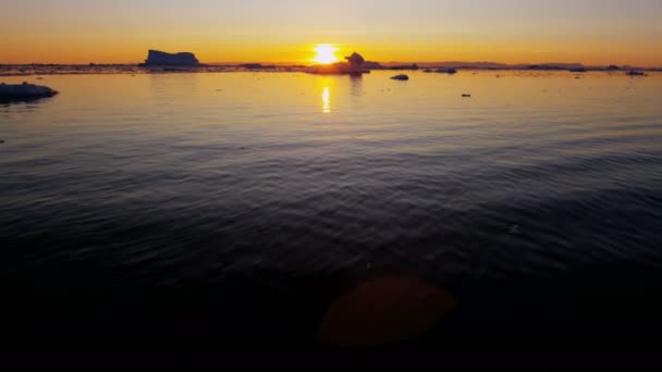 Témpanos glaciares flotando en el agua al atardecer — Vídeo de stock