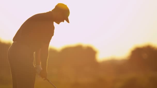 Mannelijke golfspeler golfen bij zonsondergang — Stockvideo