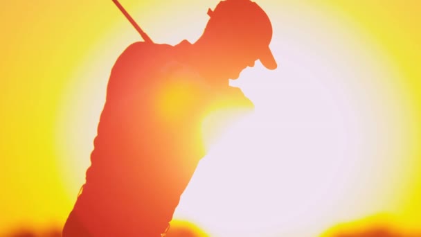 Golfista masculino jugando al golf al atardecer — Vídeos de Stock