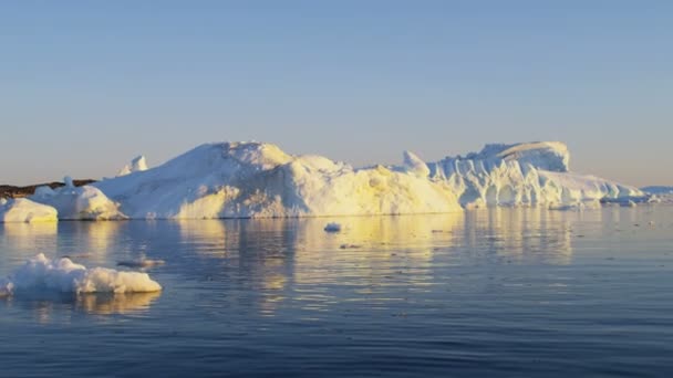 Témpanos glaciares flotando en el agua al atardecer — Vídeos de Stock