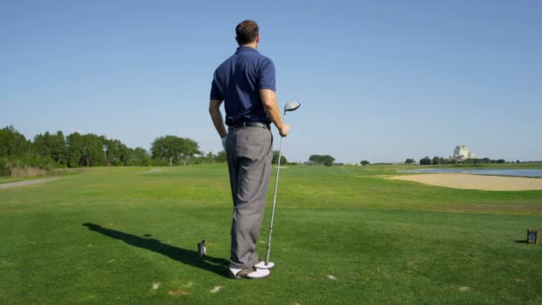 Мужчина играет в гольф на открытом воздухе — стоковое видео