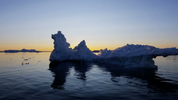 Témpanos glaciares flotando en el agua al atardecer — Vídeos de Stock