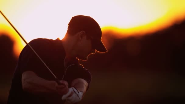 Manliga golfare spela golf vid solnedgången — Stockvideo