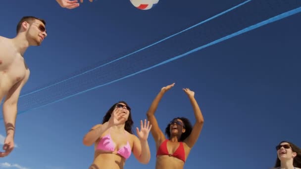 Amigos universitarios jugando voleibol en la playa — Vídeo de stock