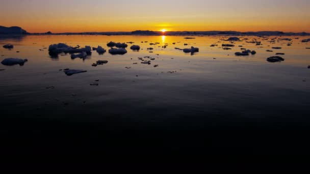 Témpanos glaciares flotando en el agua al atardecer — Vídeo de stock