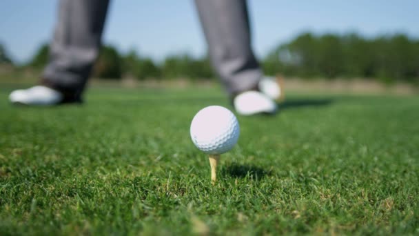 Golfista udeří míč z odpaliště — Stock video
