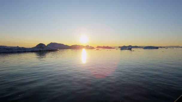 Témpanos glaciares flotando en el agua al atardecer — Vídeo de stock