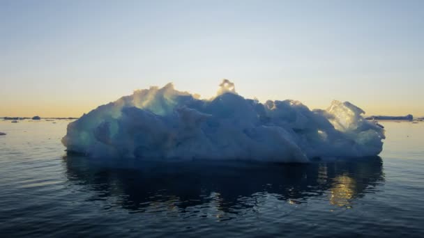 Gletsjer ice floes drijvend in het water bij zonsondergang — Stockvideo