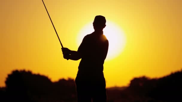 Golfista masculino jugando al golf al atardecer — Vídeos de Stock