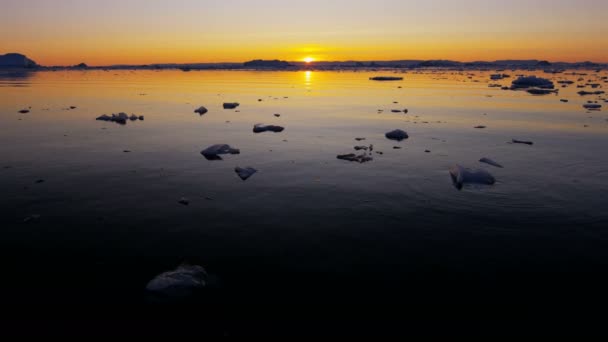 Ледниковые льды, плавающие в воде на закате — стоковое видео