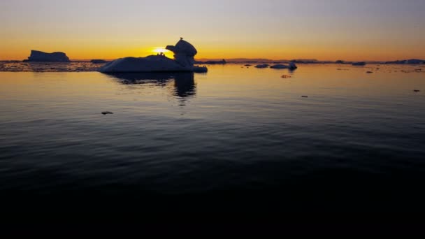 Льодовик плаває у воді на заході сонця — стокове відео