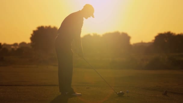 Golfista masculino jugando al golf al atardecer — Vídeos de Stock