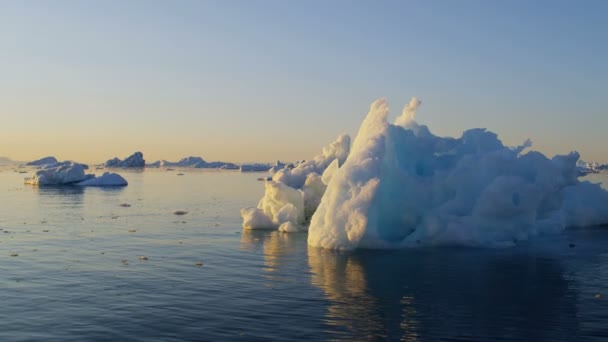 Témpanos glaciares flotando en el agua al atardecer — Vídeo de stock