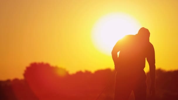 Чоловічий гольф грає в гольф на заході сонця — стокове відео