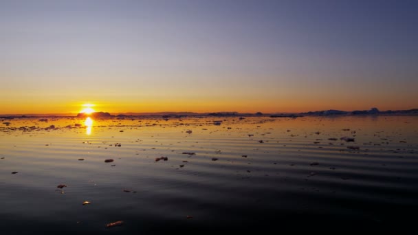 Ledovcové kry plovoucí ve vodě při západu slunce — Stock video