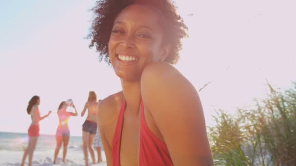 Menina sentada na praia enquanto amigos jogar bola — Vídeo de Stock