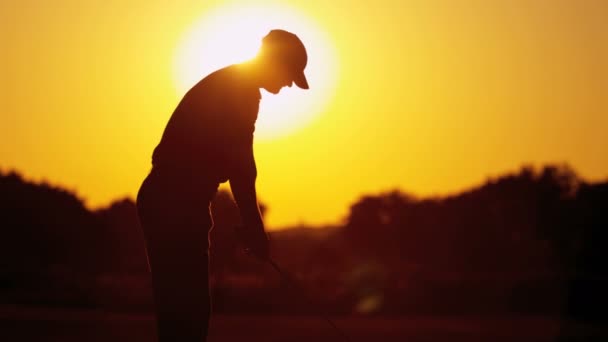 Golf profesional jugando al golf al atardecer — Vídeos de Stock