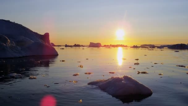 Gletsjer ice floes drijvend in het water bij zonsondergang — Stockvideo