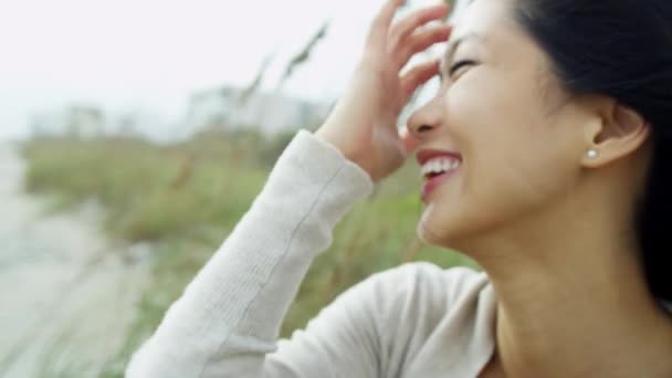 Asian woman on beach smiling to camera — Stock Video