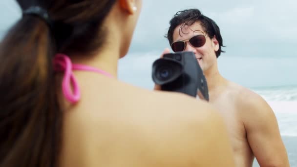 Пара на пляже с видеокамерой — стоковое видео