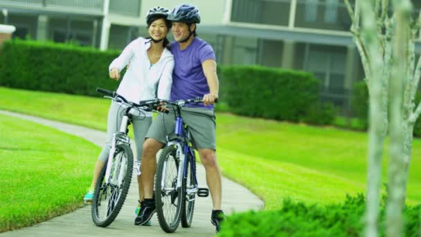 Pareja montando sus bicicletas al aire libre — Vídeo de stock