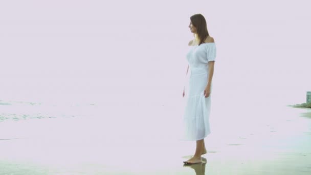 Mulher de vestido branco ao lado do oceano — Vídeo de Stock