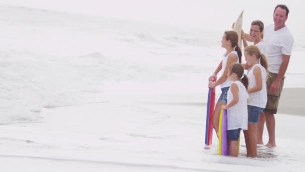 Rodiče a dcery sledují vlny na pláži — Stock video