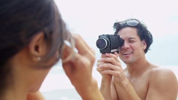 Pareja en la playa con cámara de vídeo — Vídeos de Stock