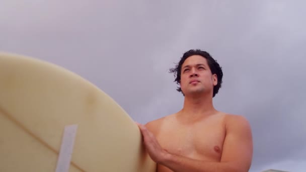 Surfer on beach watching waves — Stock Video