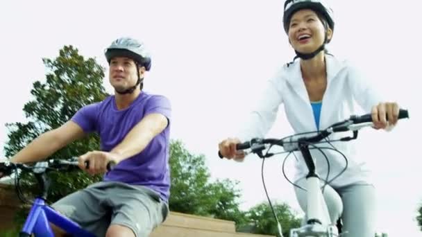 Pareja montando sus bicicletas al aire libre — Vídeos de Stock