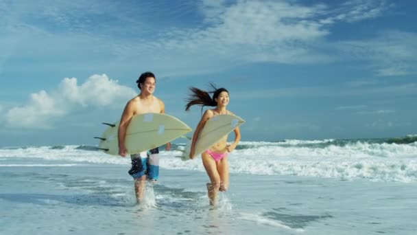 Surfen paar uitgevoerd naast Oceaan — Stockvideo