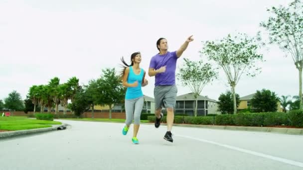 Couple in sportswear jogging in park — Stock Video