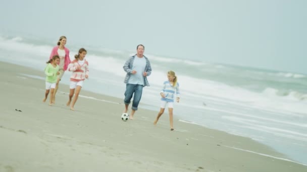 Familia caucásica disfrutando del tiempo en la playa — Vídeo de stock