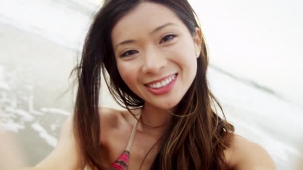 Азиатка наслаждается пляжным отдыхом — стоковое видео