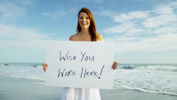 Frau am Strand mit Hinweistafel — Stockvideo
