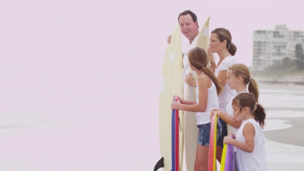 Padres e hijas viendo olas en la playa — Vídeo de stock