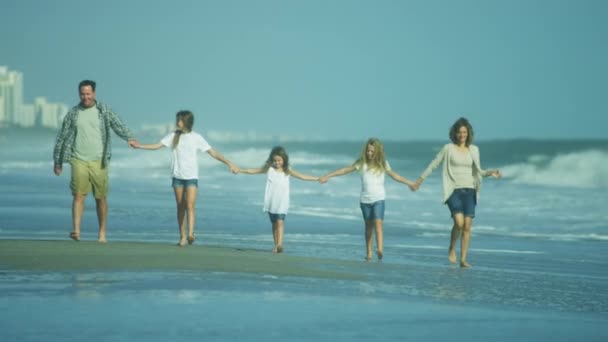 ビーチの上を歩く娘を持つ両親 — ストック動画