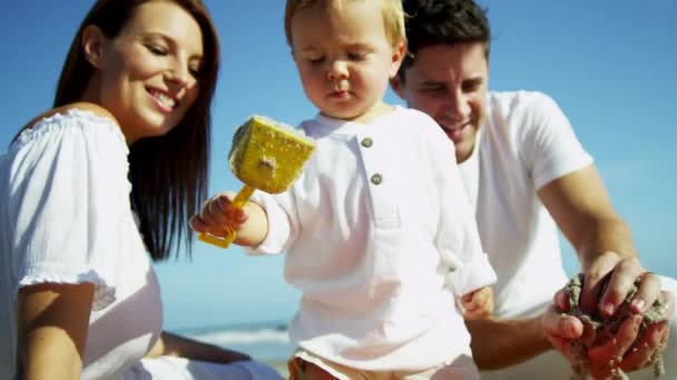 Eltern mit Sohn spielen am Sandstrand — Stockvideo