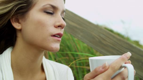 Girl on beach drinking coffee — Stock Video